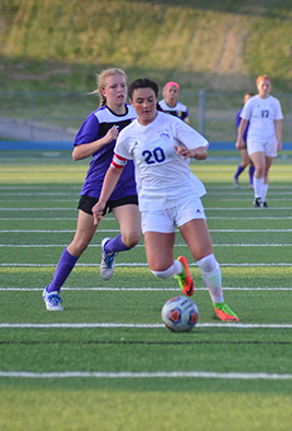 Nina Stine dribbles a ball down the field in a match against Blue Springs. Photo by Autumn Campbell.