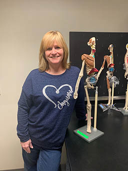 Biomed teacher Pattie Balano poses with a student project.
Photo by Hallie Robinson
