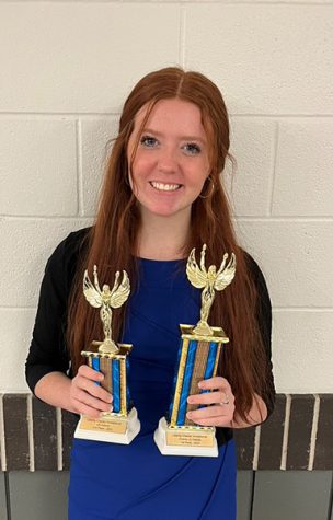 Senior Allison Cooper holds two debate trophies. She reached 150 wins earlier this year. Photo submitted