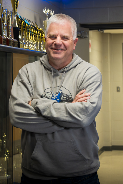 Colonel Stan Cole poses in front of the JROTC trophy case. Cole has been awarded South's Teacher of the Year.