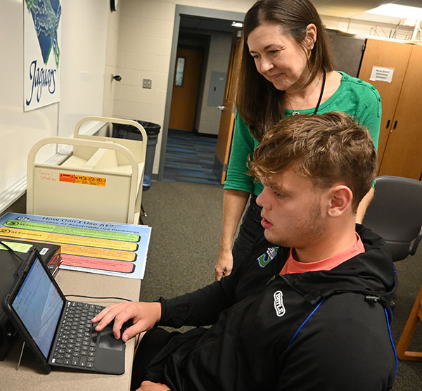 Erin Hunt helps a student on a test. When not teaching she works as a lawyer. Photo by Nadia Katzenberger
